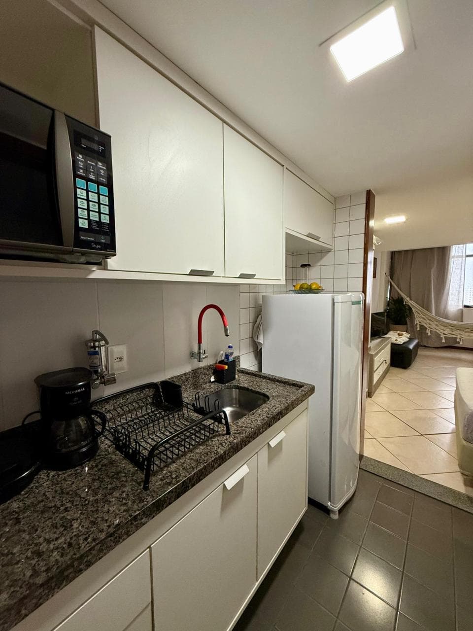 Cozinha compacta equipada com micro-ondas e pia