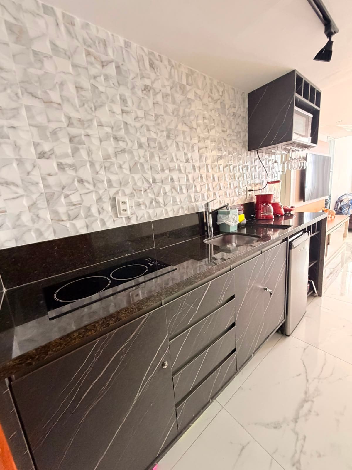 Kitchenette com bancada de granito, cooktop e micro-ondas
