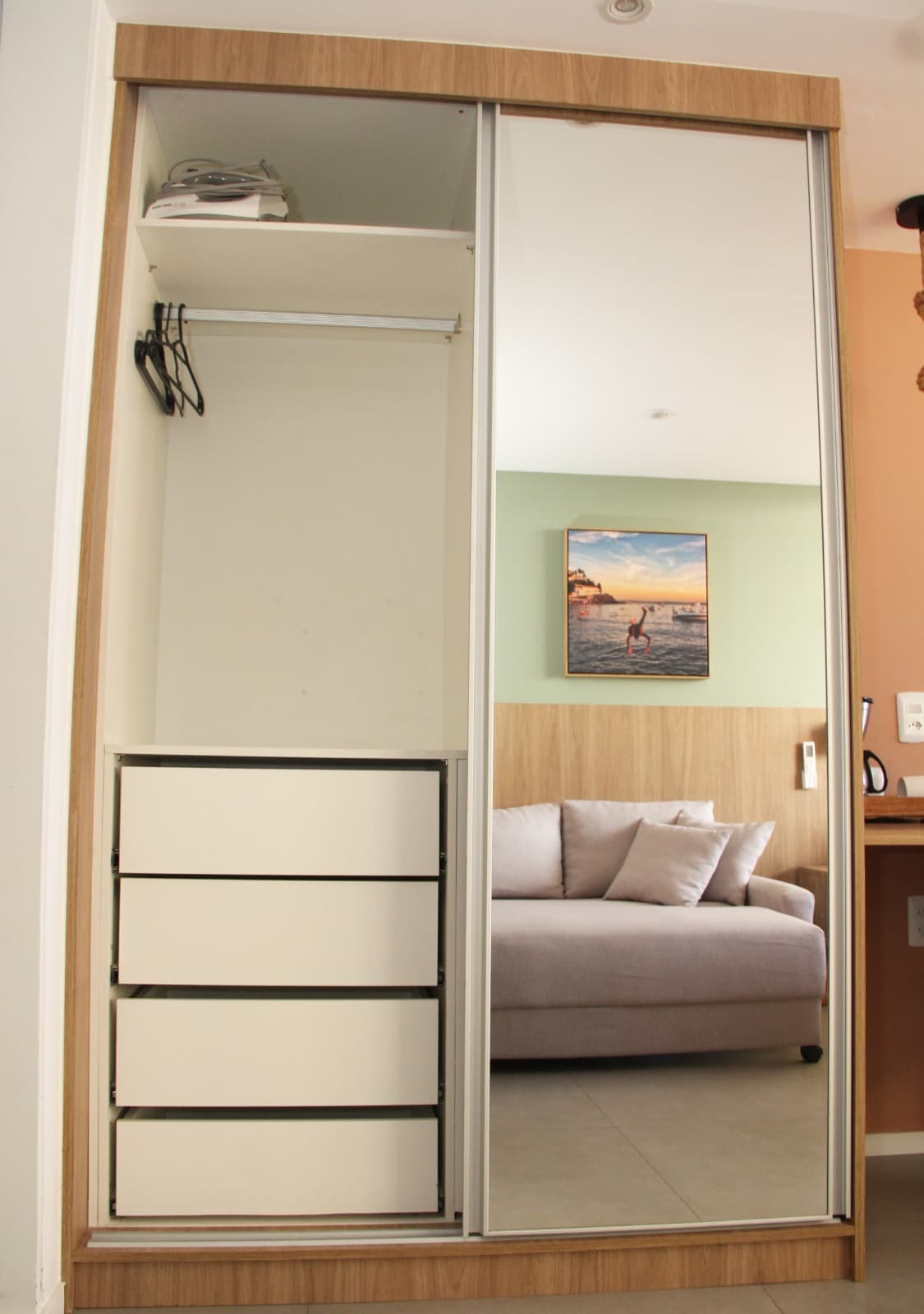 Quarto com espelho de corpo inteiro e cama ao fundo