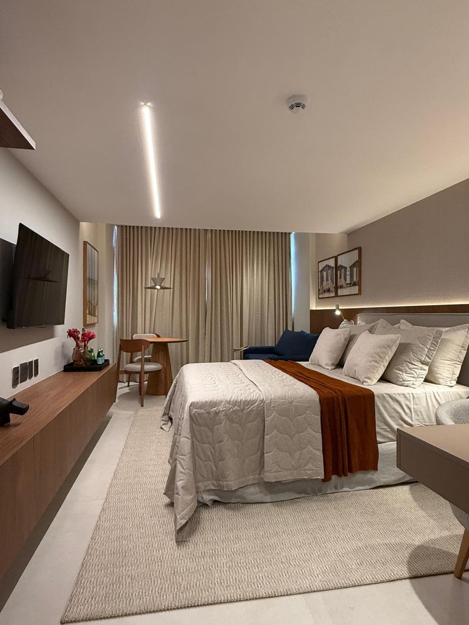 Quarto com cama, TV e poltrona