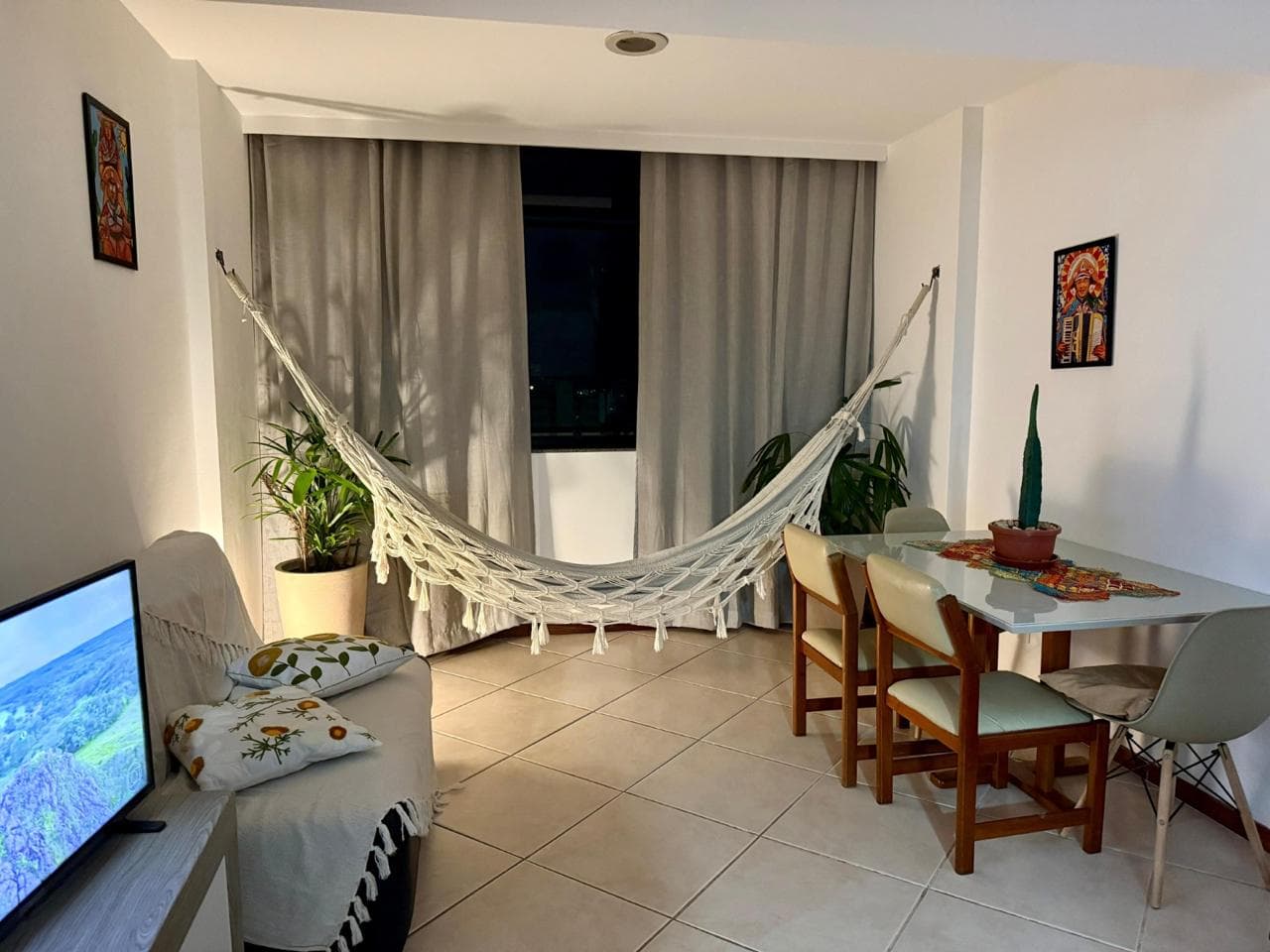 Sala de estar com rede e mesa de jantar ao anoitecer