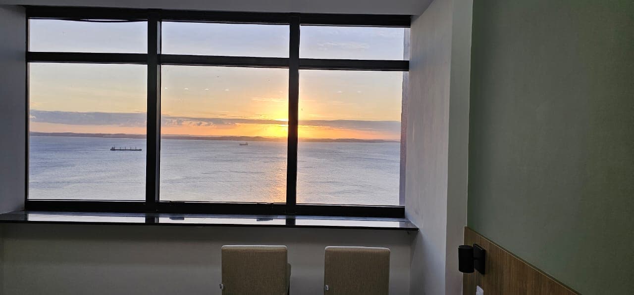 Vista da Baía de Todos os Santos ao pôr do sol pela janela do flat